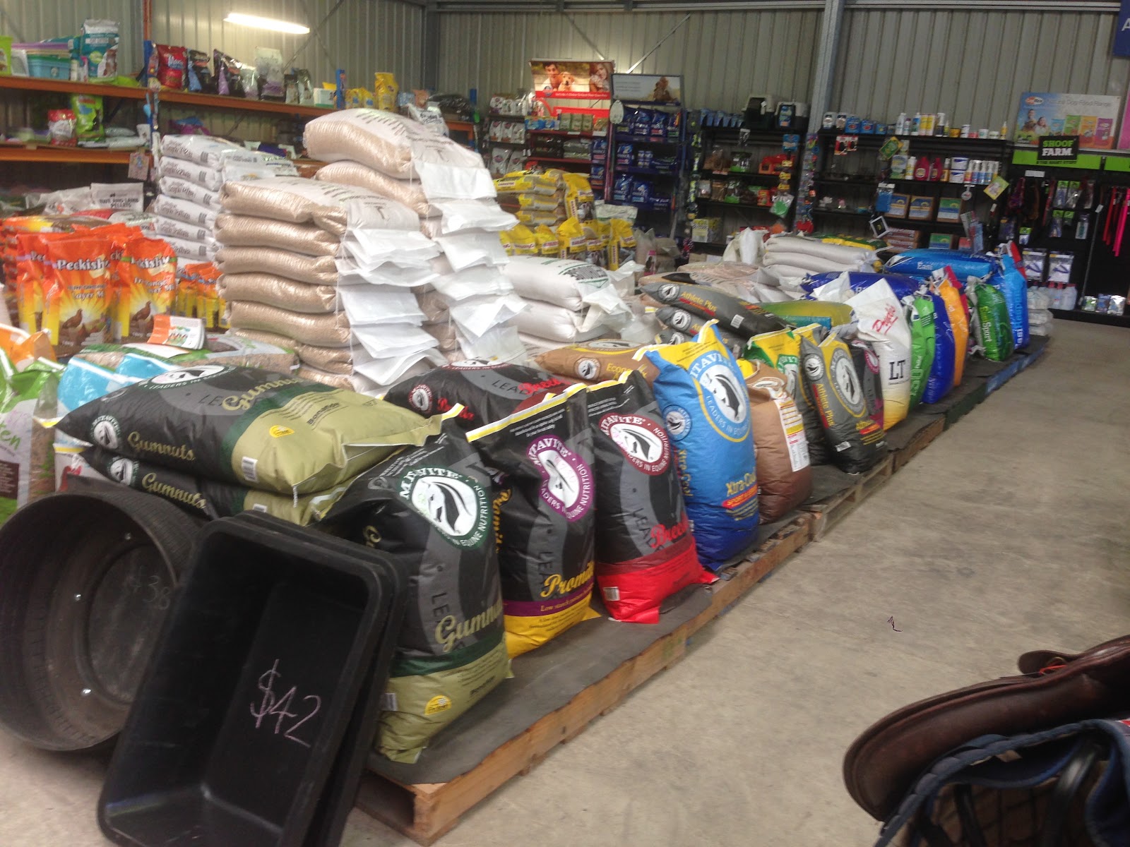 Rows of bagged horse and stock feed on pallets inside the shed
